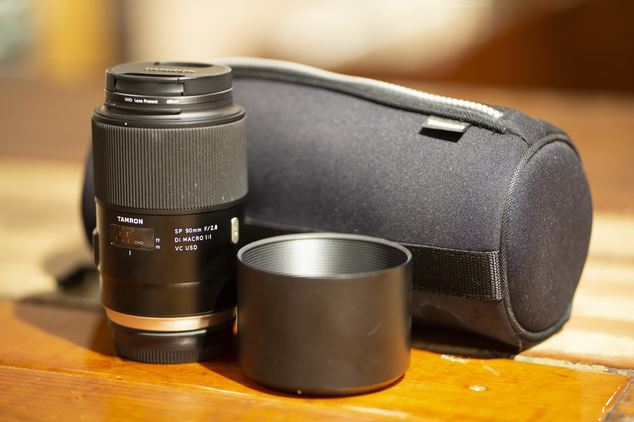 A Tamron lens rental including a Tamron lens and lens case, a DHG filter, and a lens hood.