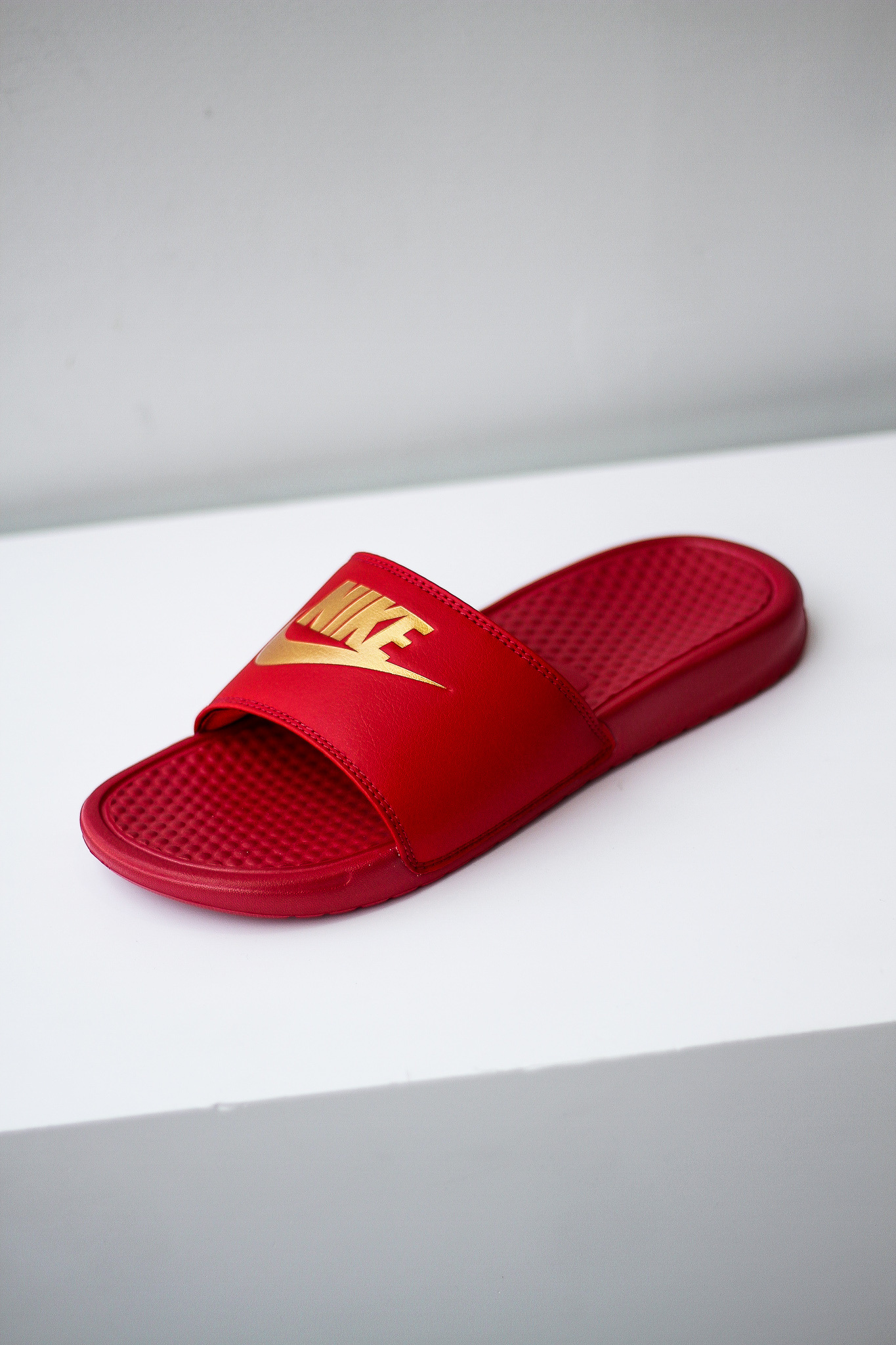 red and gold nike slides