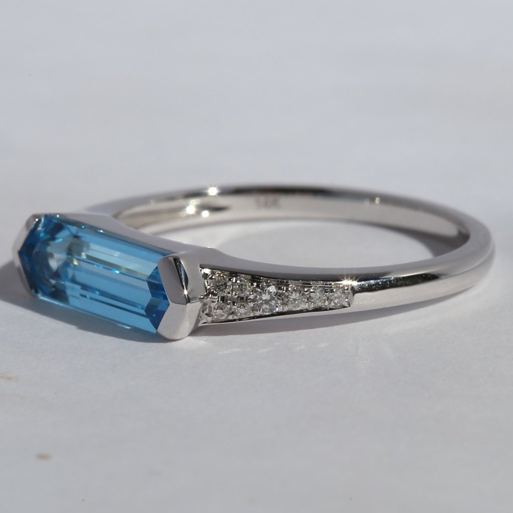 American Jewelry 14k White Gold .08ctw Round Brilliant Diamond & Elongated Blue Topaz Ring (Size 7)