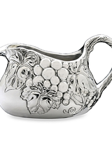 Arthur Court Designs Grape Gravy Boat<br />
Our grape motif displays on each side of this piece as darker lines define each veiny leaf and piece of fruit. Vines also twirl into view on the bottom of this handmade, aluminum boat before arching up to form the handle.