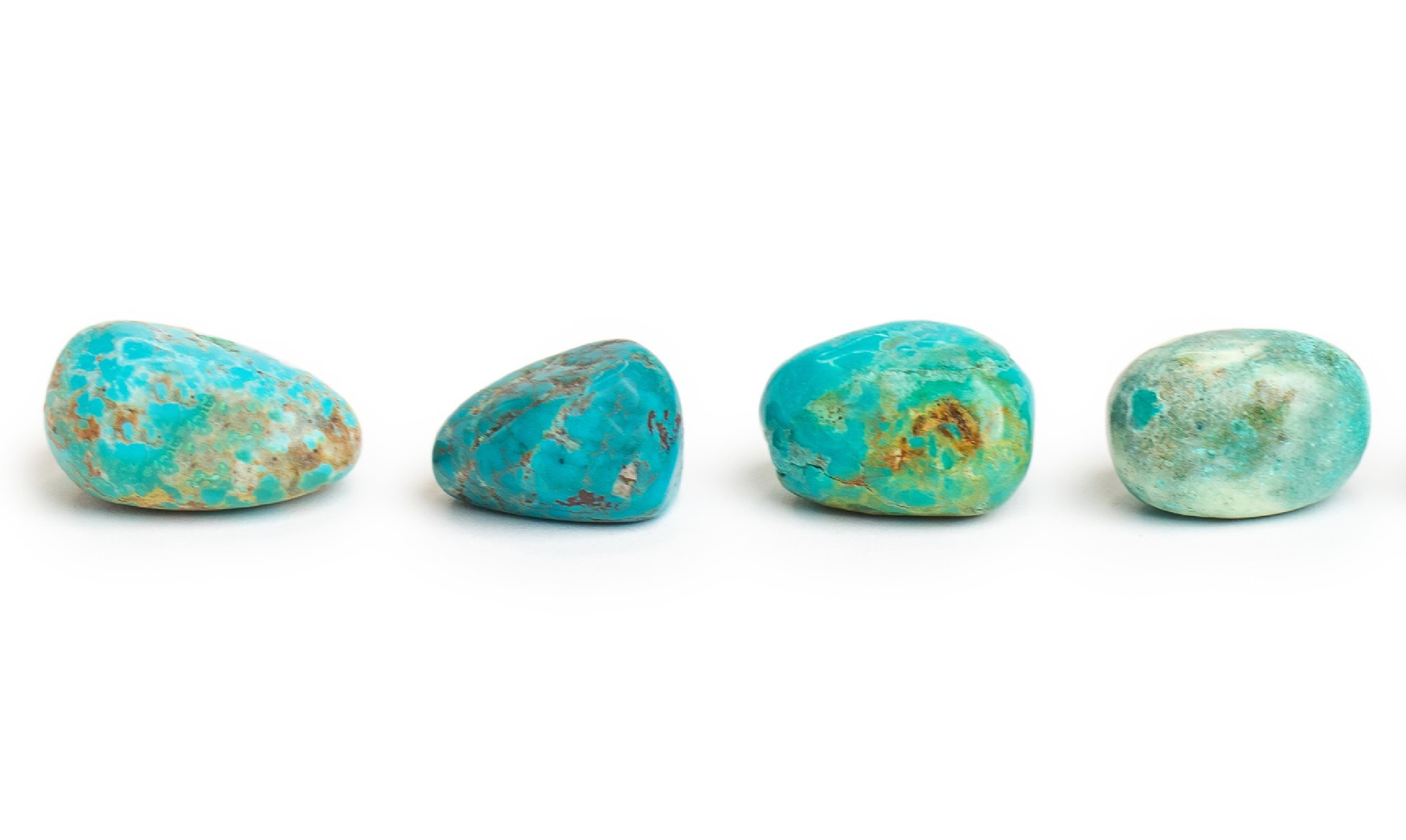 Four pieces of tumbled bright blue turquoise. All 4 are smaller pieces with brown and yellow inclusions