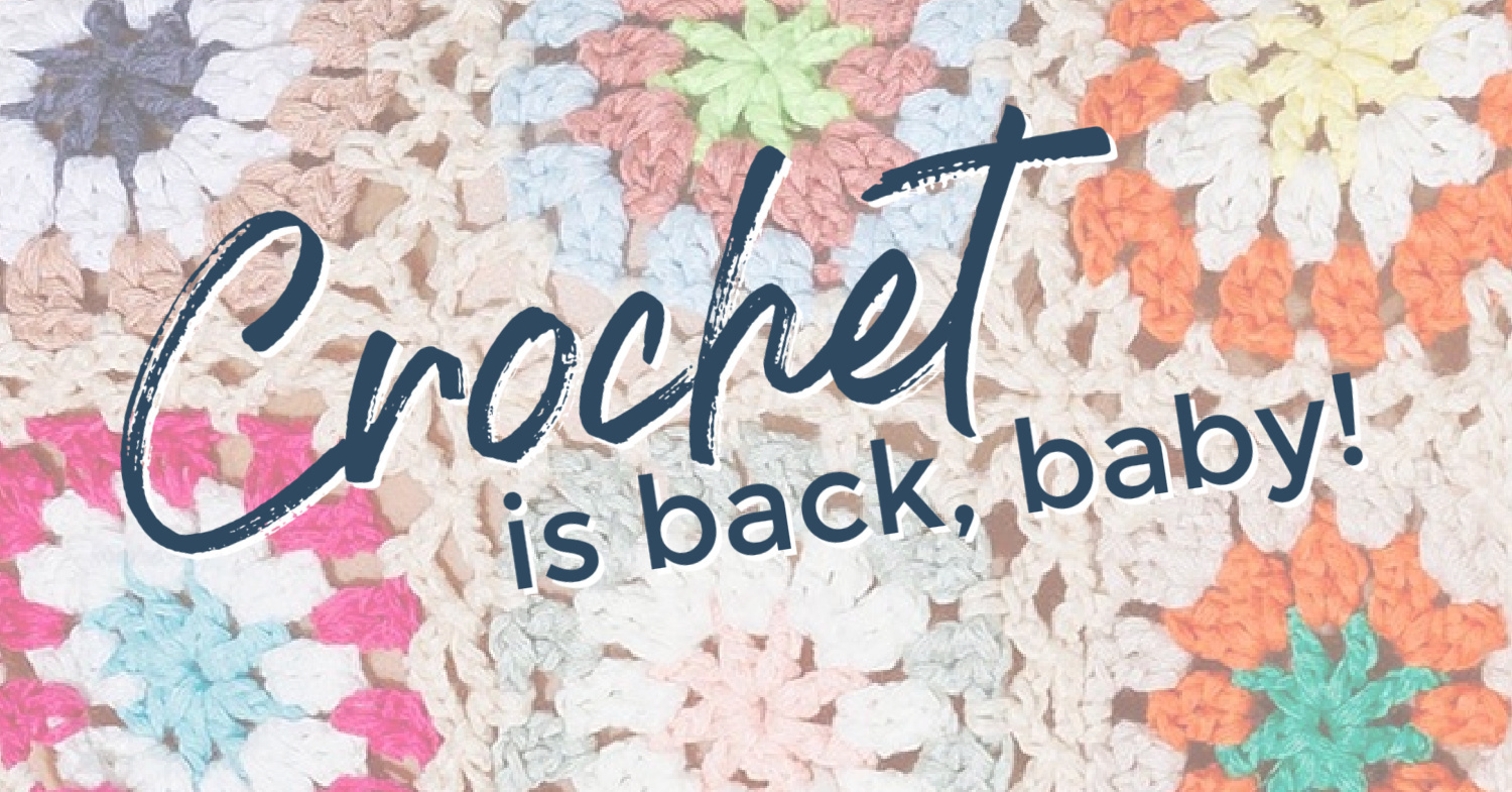 Faded but colorful square crochet background with text overlaid that reads "Crochet is back, baby!" in navy blue font. 
