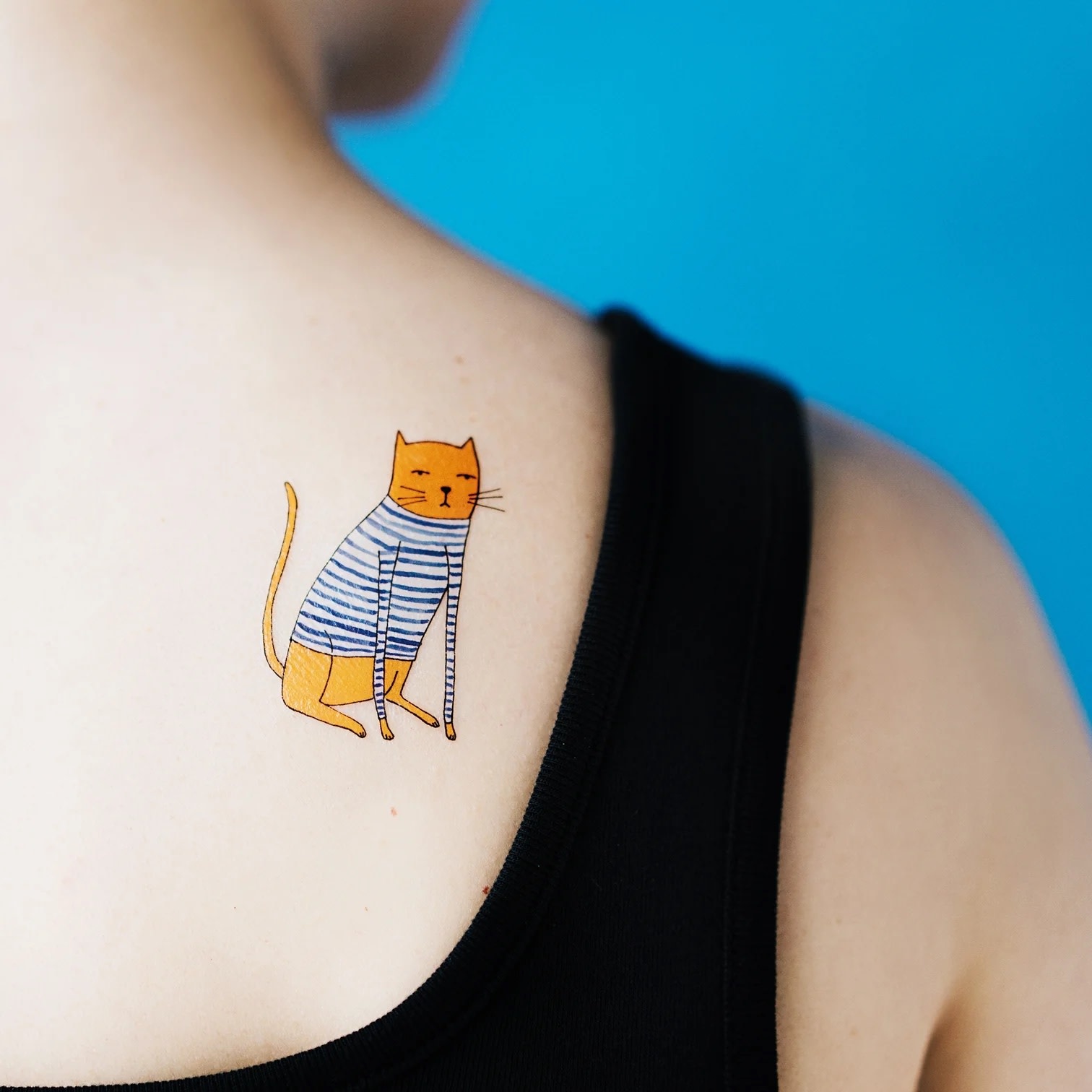 tattoo of a blue cat on shoulder