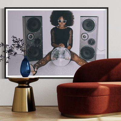 Framed Print on Rag Paper African woman in black dress and sunglasses holding disco ball by Vladimir Vladimirov via Getty Images Gallery