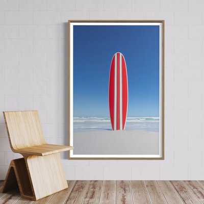 Framed Print on Rag Paper Red and white striped retro surfboard with the ocean in the background by  John White Photos via Getty Images Gallery