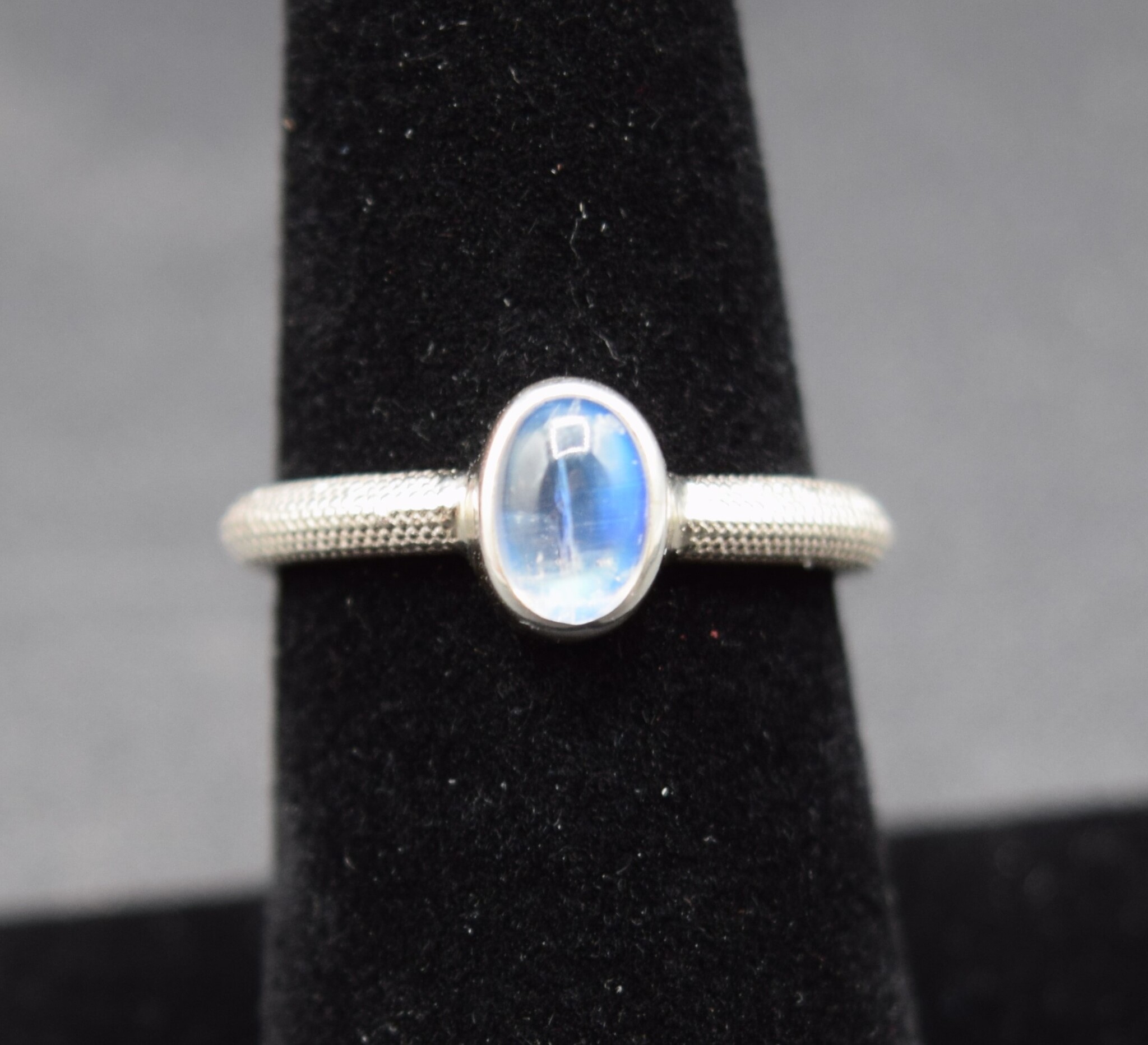 STB 001 SS Rainbow Moonstone 7mm Oval, Bezel Set Textured Snake Band, Ring Size 7