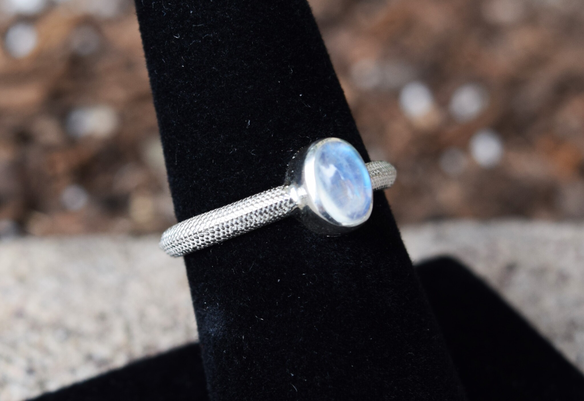 STB 001 SS Rainbow Moonstone 7mm Oval, Bezel Set Textured Snake Band, Ring Size 7