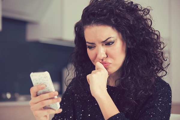 Model looking down at mobile phone with contemplative expression