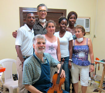 Tom Metzler and David Gage of New York work with violin repair trainees in an impromptu repair shop in Havana, Cuba.