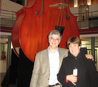 Tom and Barbara stand in front of the world's largest cello, in Mirecourt France.