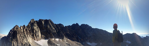 A climbing looking at the horizon atop a mountain