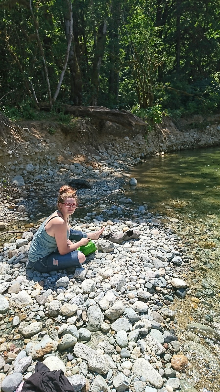 woman cleaning her clothes by the creek