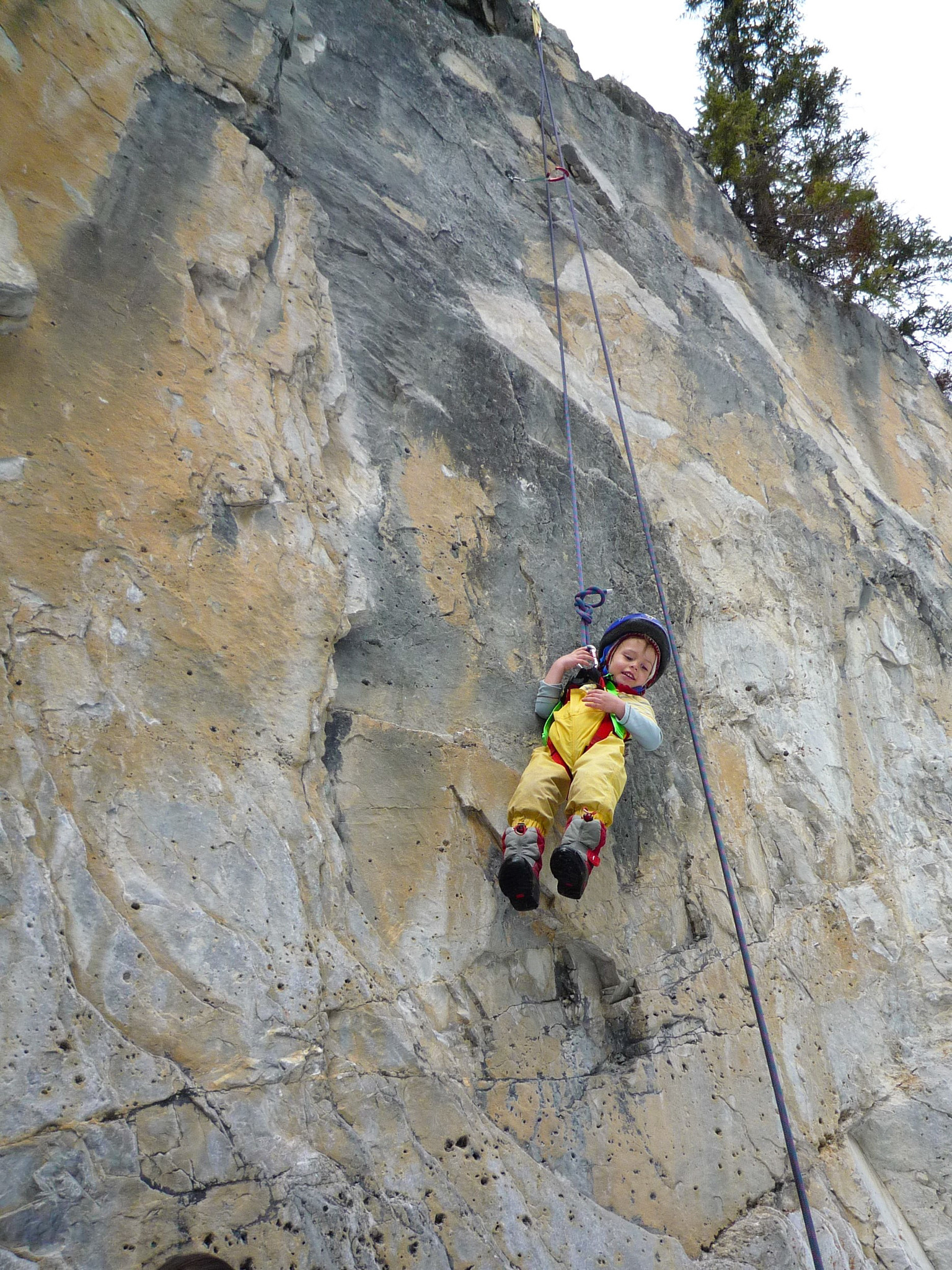 a kid swining on a climbing rope