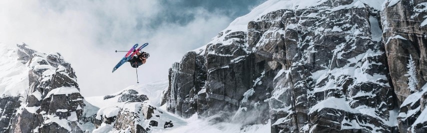 Skieur en grab dans les airs, en bas d'une parois