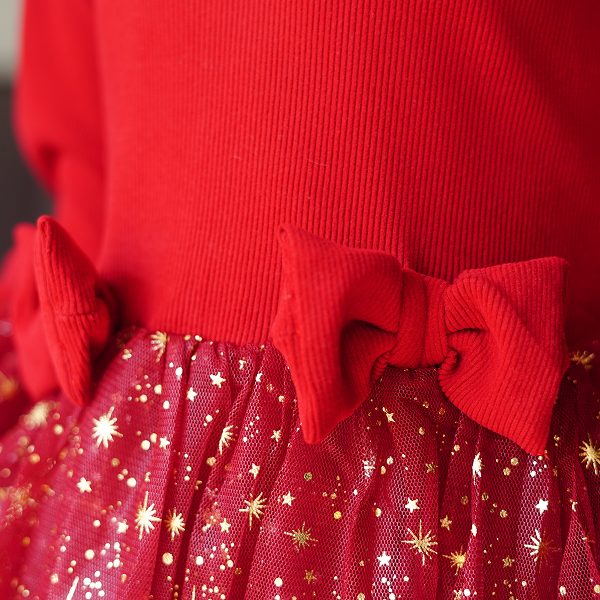 Gros plan sur une robe rouge ornée d'étoiles dorées, collection Looks de Noël enfants 2025.