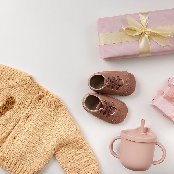 Un cadeau pour bébé : un pull doux et une tasse rose, parfaits pour 2025.