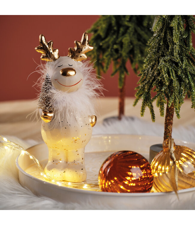 Renne debout tenant un sapin