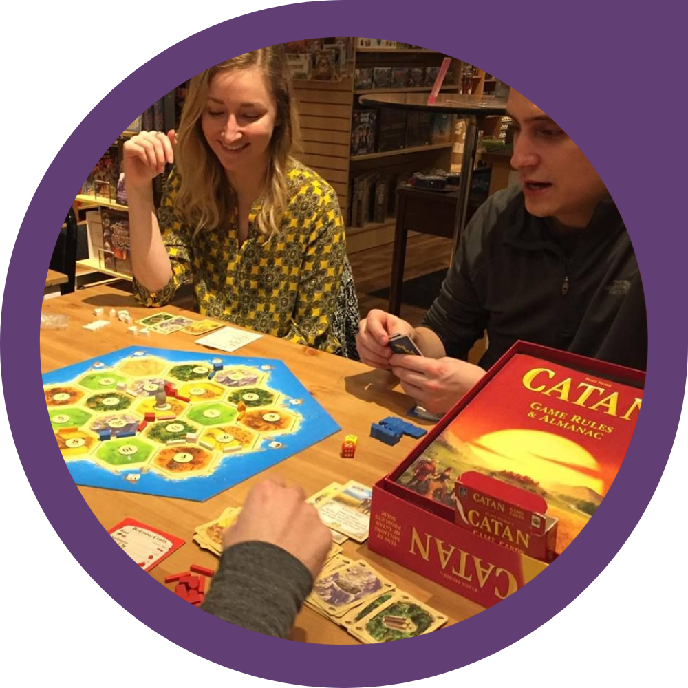 A group gather around an exciting game of Catan