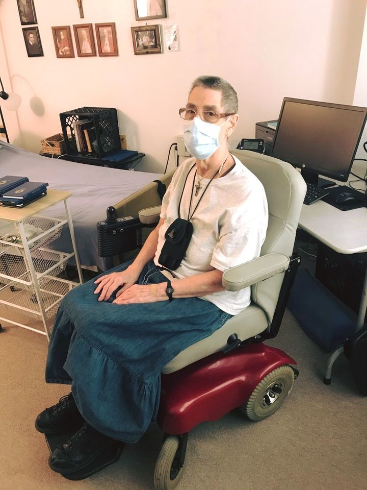 Helen seated in her power wheelchair in her apartment.