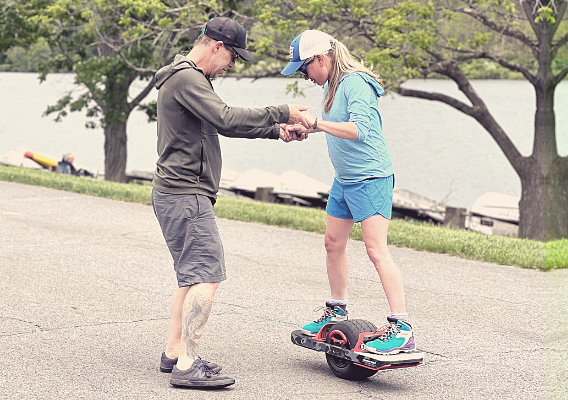 carey at ski shack helping woman try out a onewheel