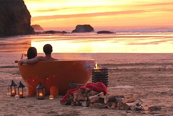 Couple in dutchtub on beach at sunset