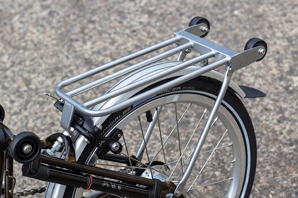 Closeup of a glossy silver rear rack on an equally glossy black lacquer Brompton folding bike