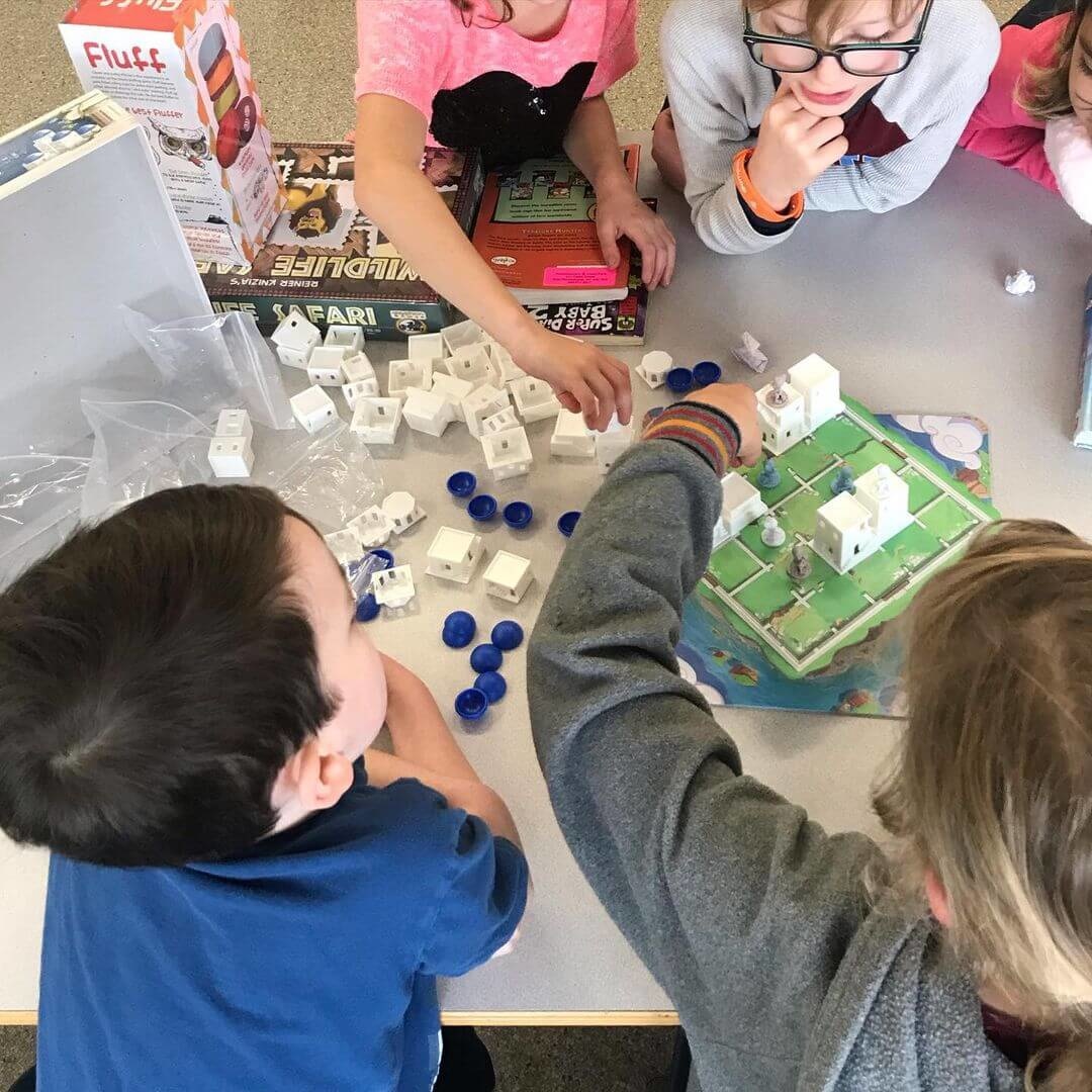 Lower elementary age homeschool kids playing Santorini