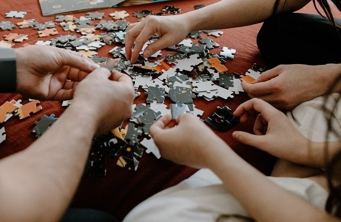 Hands putting together a jigsaw puzzle