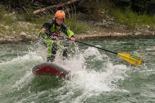  JHKS employee punching a wave on his SUP 