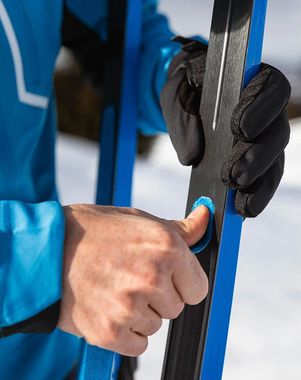 Gros plan d'un skieur tenant son ski de fond.