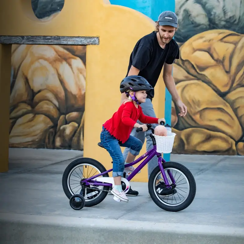 Homme guidant un enfant sur son vélo pour enfants.