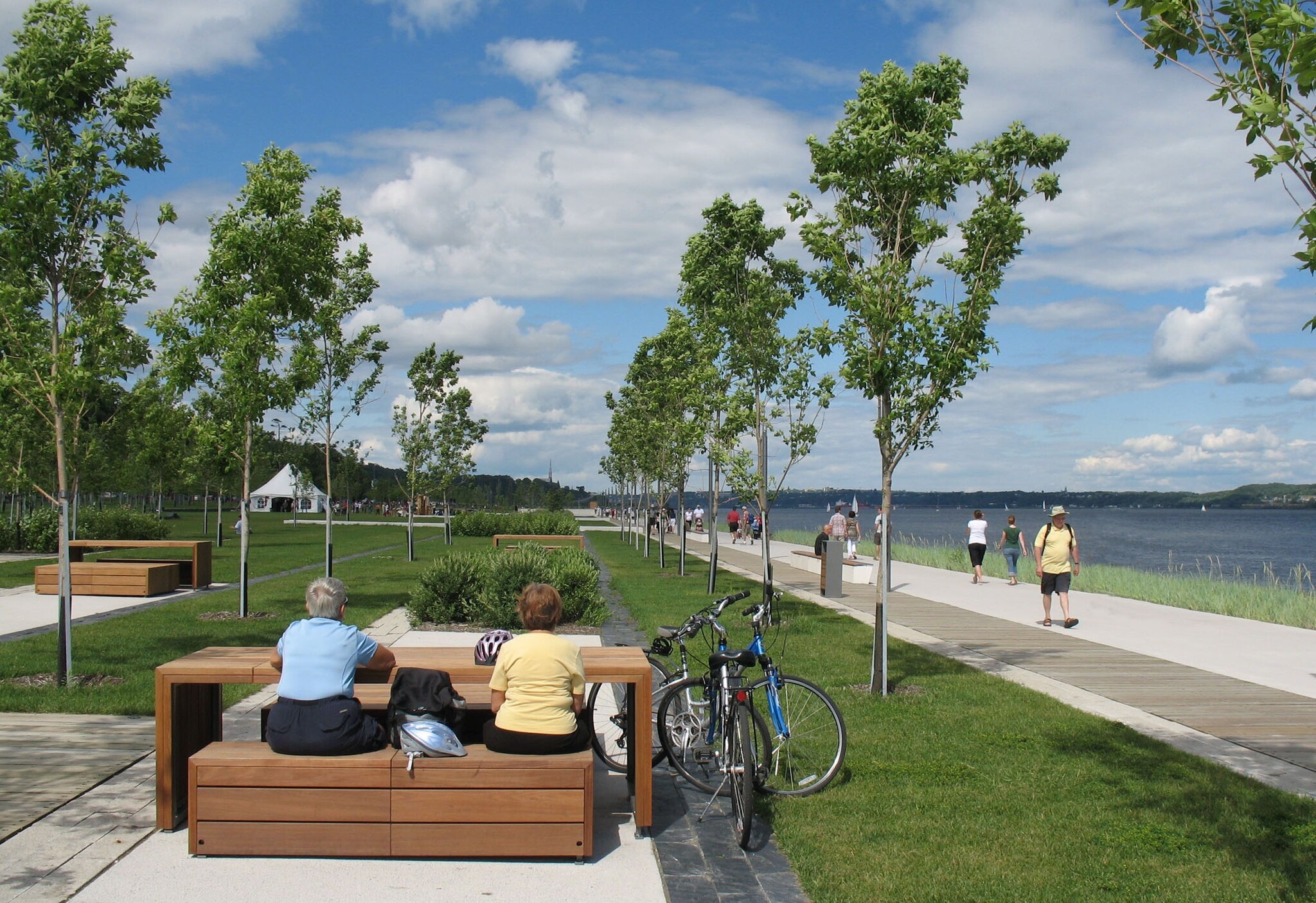 Passage cyclable du corridor du Littoral à Québec, avec signalisation, végétation et vue sur le fleuve.