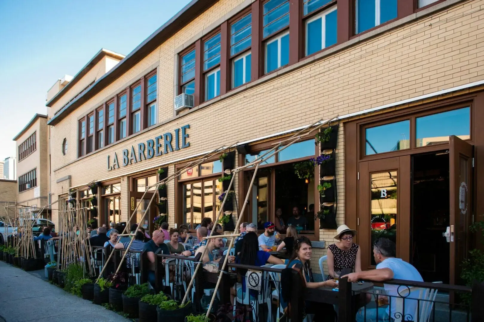 Terrasse de La Barberie à Québec dans le quartier Saint-Roch, bondée de clients profitant d’une journée ensoleillée.