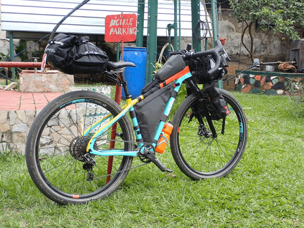 Vélo de gravel équipé de sacs de bikepacking fixés au cadre, prêt pour une expédition autonome sur route et sentier.