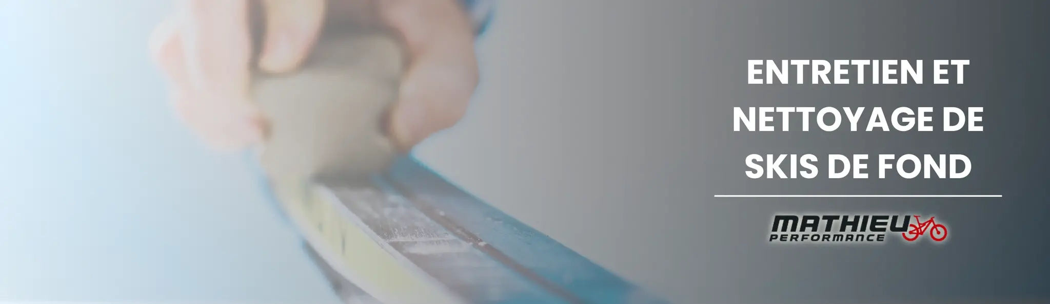 Technicien nettoyant et cirant une paire de skis de fond sur un établi d’atelier, avec outils d’entretien et produits spécialisés visibles en arrière-plan.
