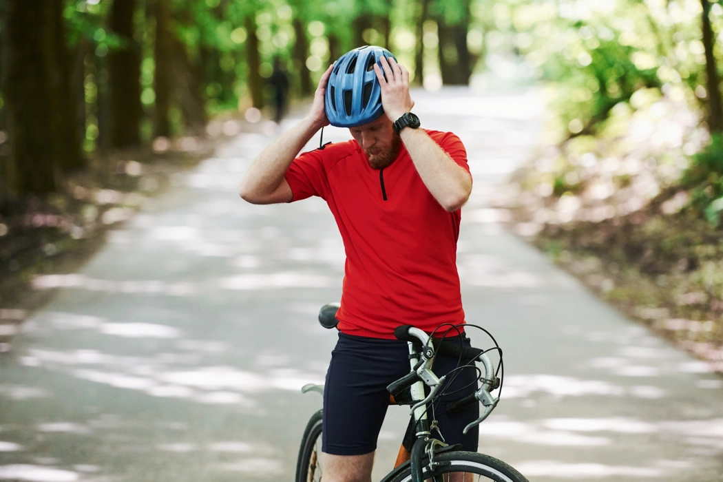 Cycliste arrêté sur une route forestière, illustrant les habitudes qui ralentissent les cyclistes et nuisent à la performance à vélo.