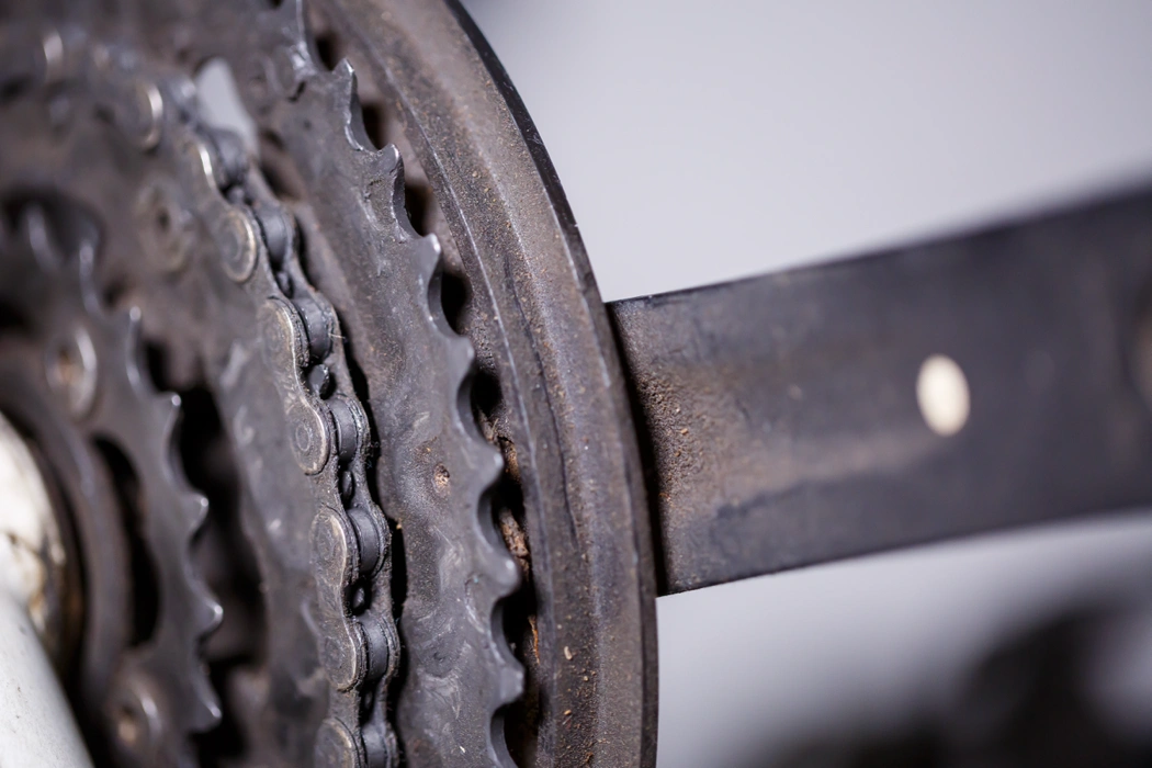 Gros plan sur une chaîne et un plateau usés, illustrant une transmission de vélo inefficace qui réduit le rendement.