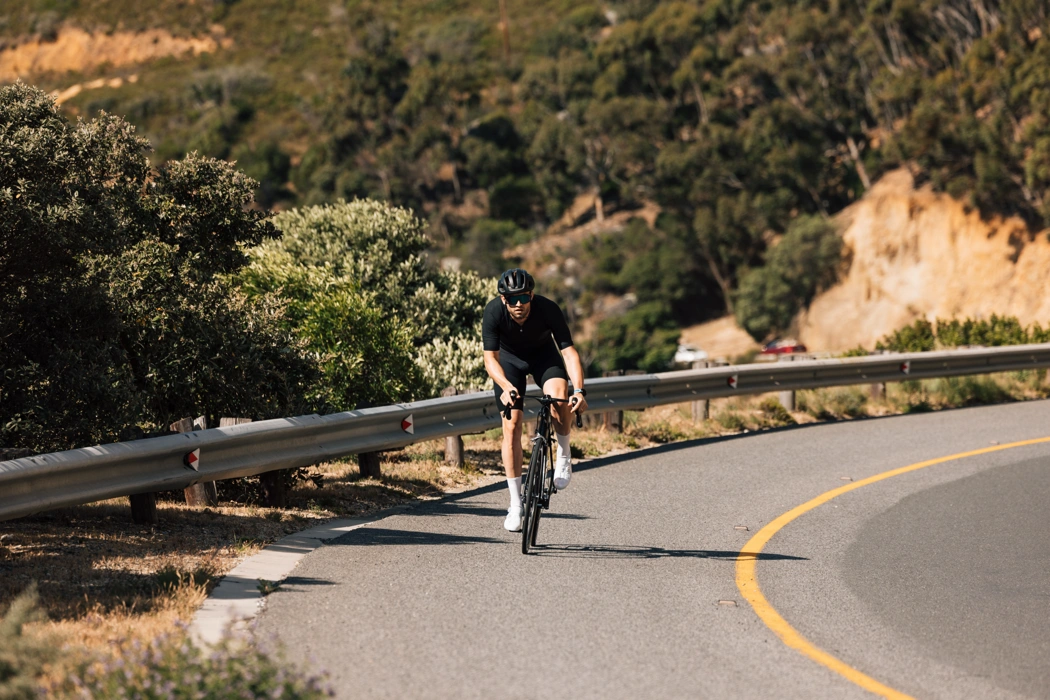 Cycliste sur route en montée dans un virage, illustrant ce qui change quand la route monte à vélo.