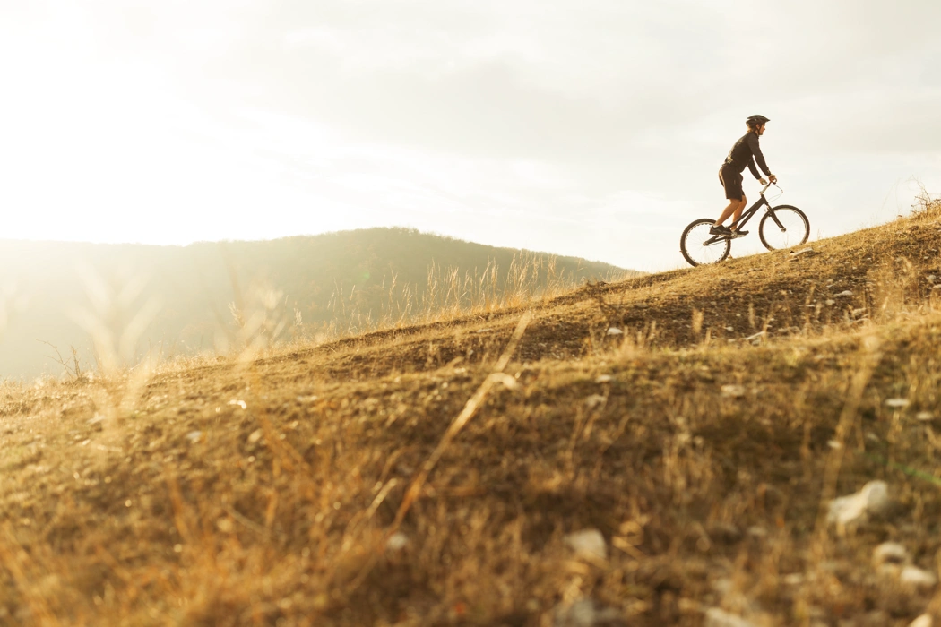 Cycliste qui grimpe une pente avec un braquet trop difficile, illustrant une montée à vélo plus exigeante.