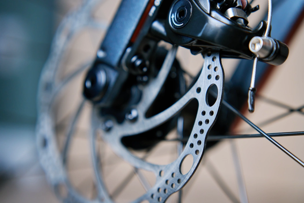 Gros plan sur un disque de frein de vélo, illustrant des freins qui frottent et rendent le vélo plus difficile à pédaler.