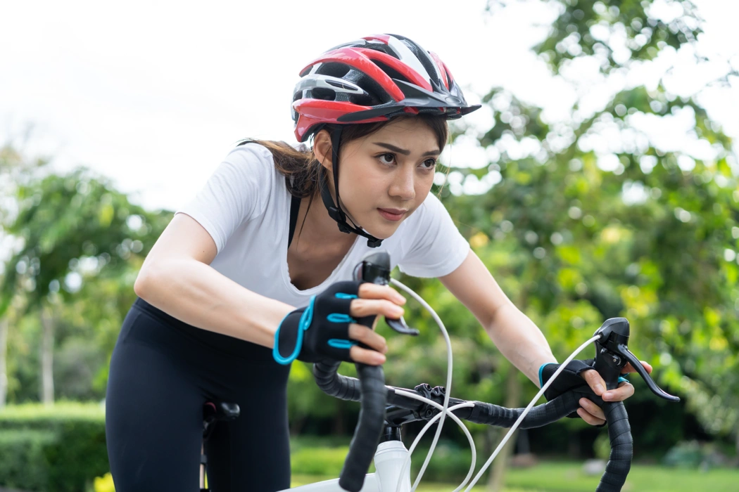 Cycliste concentrée en position sportive, illustrant les signes d’une surcharge physique à vélo.