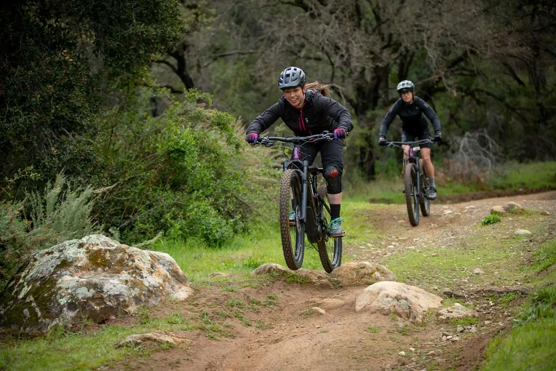 Deux cyclistes en sentier forestier, illustrant une pratique du vélo plus confortable après de bons ajustements.