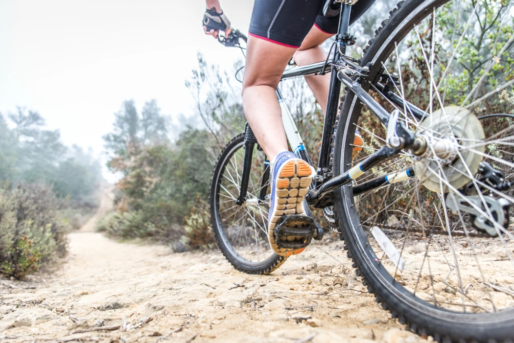 Cycliste sur sentier plat, illustrant une mauvaise adaptation du braquet au terrain qui oblige à pédaler trop vite.