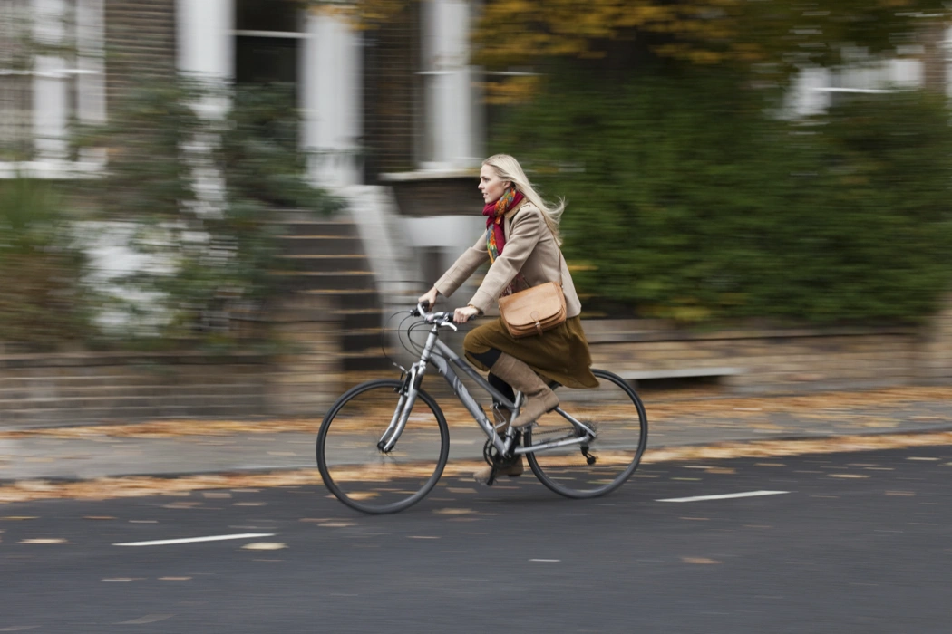 Cycliste urbaine à vélo, illustrant une mauvaise utilisation des vitesses qui augmente la cadence de pédalage.