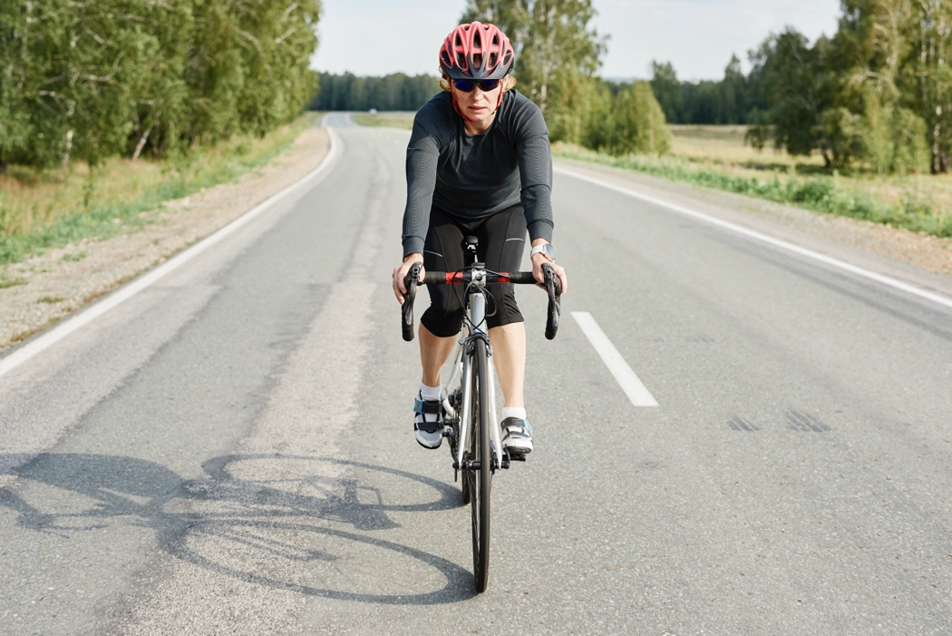 Cycliste sur route illustrant les vérifications à faire pour améliorer la vitesse et le rendement du vélo.