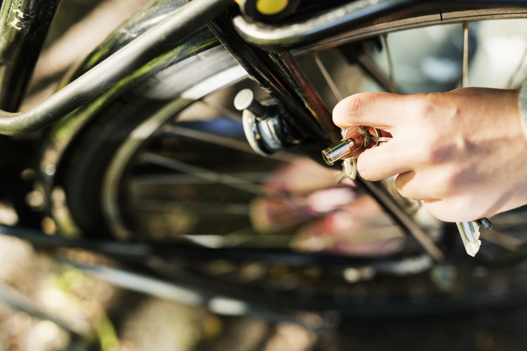Main ajustant une roue de vélo pendant un entretien mécanique pour vérifier la stabilité et le bon fonctionnement du vélo.