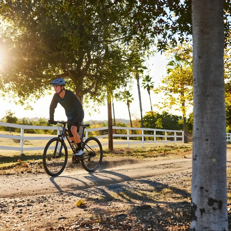 Cycliste roulant sur un chemin pour illustrer les ajustements qui améliorent la stabilité du vélo sur terrain irrégulier.