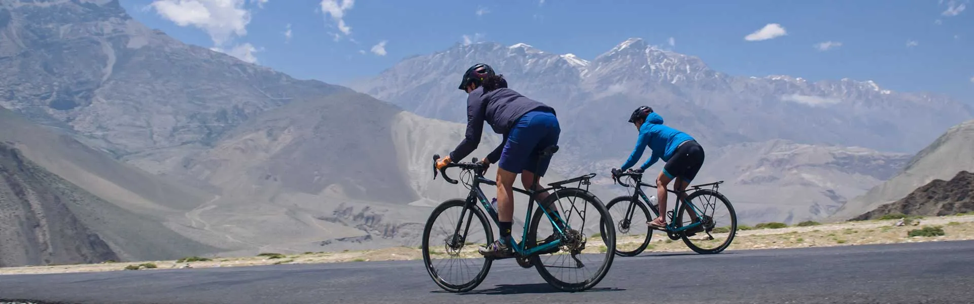 Deux cyclistes en montée illustrant une cadence de pédalage efficace pour réduire la pression sur les genoux.