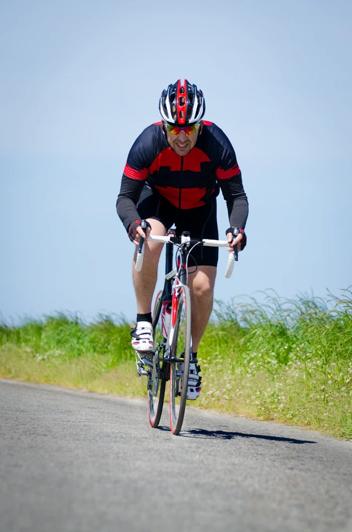 Cycliste en plein sprint court sur un vélo de route pour développer l’explosivité.