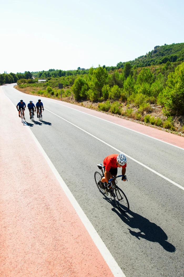 Groupe de cyclistes sur route pendant des intervalles longs pour développer l’endurance intense.